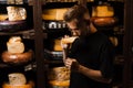 Handsome buyer in cheese shop sniff and enjoy limited gouda cheese. Snack tasty piece of cheese for appetizer.