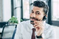 handsome call center operator smiling at camera while using headset. Royalty Free Stock Photo