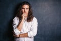 Handsome calm man. Strong boy on an isolated dark background in the studio