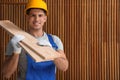 Handsome carpenter wearing uniform near wall. Space for text