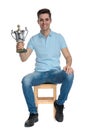 Handsome casual guy smiling and holding his trophy Royalty Free Stock Photo