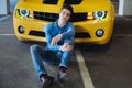 Handsome casual man sitting near the modern yellow sport car. Fashion. Modern. Advertising Royalty Free Stock Photo