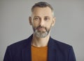 Handsome caucasian hipster man with beard face portrait on grey background