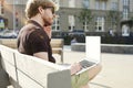 Handsome caucasian hipster man working on laptop sitting outdoor in a park. Summer sunshine day. Concept of young business people Royalty Free Stock Photo