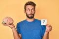 Handsome caucasian man with beard holding brain and question mark smiling looking to the side and staring away thinking Royalty Free Stock Photo
