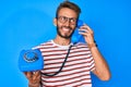 Handsome caucasian man with beard holding vintage telephone angry and mad screaming frustrated and furious, shouting with anger Royalty Free Stock Photo