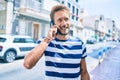 Handsome caucasian man with beard smiling happy outdoors speaking on the phone Royalty Free Stock Photo