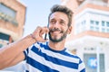 Handsome caucasian man with beard smiling happy outdoors speaking on the phone Royalty Free Stock Photo