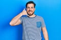 Handsome caucasian man with beard wearing casual striped t shirt smiling doing phone gesture with hand and fingers like talking on Royalty Free Stock Photo