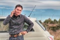 Handsome caucasian man leaning on car talking with mobile phone Royalty Free Stock Photo