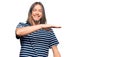 Handsome caucasian man with long hair wearing casual striped t-shirt gesturing with hands showing big and large size sign, measure Royalty Free Stock Photo