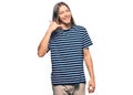 Handsome caucasian man with long hair wearing casual striped t-shirt smiling doing phone gesture with hand and fingers like Royalty Free Stock Photo