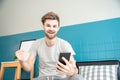 Handsome caucasian man sitting on sofa and play on cell phone ,surf the social media ,in the living room on morning time.Relax and Royalty Free Stock Photo