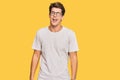 Handsome caucasian man wearing casual clothes and glasses winking looking at the camera with sexy expression, cheerful and happy Royalty Free Stock Photo