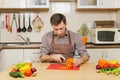 Handsome caucasian young man, sitting at table. Healthy lifestyle. Cooking at home. Prepare food. Royalty Free Stock Photo