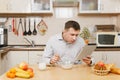 Handsome caucasian young man, sitting at table. Healthy lifestyle. Cooking at home. Prepare food. Royalty Free Stock Photo