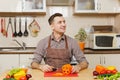 Handsome caucasian young man, sitting at table. Healthy lifestyle. Cooking at home. Prepare food. Royalty Free Stock Photo