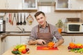 Handsome caucasian young man, sitting at table. Healthy lifestyle. Cooking at home. Prepare food. Royalty Free Stock Photo