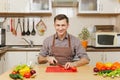 Handsome caucasian young man, sitting at table. Healthy lifestyle. Cooking at home. Prepare food. Royalty Free Stock Photo