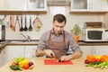 Handsome caucasian young man, sitting at table. Healthy lifestyle. Cooking at home. Prepare food. Royalty Free Stock Photo