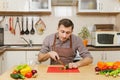 Handsome caucasian young man, sitting at table. Healthy lifestyle. Cooking at home. Prepare food. Royalty Free Stock Photo