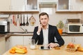 Handsome caucasian young man, sitting at table. Healthy lifestyle. Cooking at home. Prepare food. Royalty Free Stock Photo