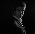 Handsome charismatic man looking with smiling on dark shadow dramatic light. Art. Black and white closeup portrait Royalty Free Stock Photo