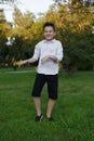 A handsome and charismatic young boy doing pranks and dancing outside in the park.