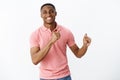 Handsome charming young african american masculine guy in pink polo shirt gesturing with hands as dancing, having fun Royalty Free Stock Photo