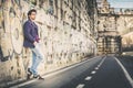 Handsome and charming young man outdoors leans against a wall in the city Royalty Free Stock Photo