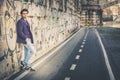 Handsome and charming young man outdoors leans against a wall in the city Royalty Free Stock Photo