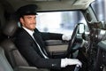 Handsome chauffeur driving limousine smiling