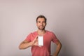 Handsome cheerful hipster guy in casual t-shirt holding mobile phone with empty mock up copy space screen Royalty Free Stock Photo