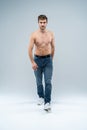 Handsome cheerful man. Full length of handsome young shirtless man in jeans looking at camera with smile while standing Royalty Free Stock Photo