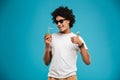 Handsome cheerful young african curly man drinking cocktail coconut showing thumbs up. Royalty Free Stock Photo