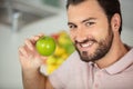 handsome cheerful young man holding apple Royalty Free Stock Photo