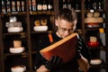 Handsome cheese sommelier holding and sniff limited gouda cheese. Snack tasty piece of cheese for appetizer.