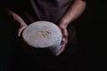 Handsome cheesemaker is checking cheeses in his workshop storage. Royalty Free Stock Photo