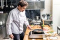 handsome chef frying meat