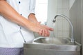 Handsome chef washing hands in commercial kitchen