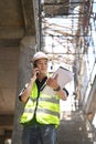 Handsome civil engineer manager standing at construction site and having phone conversation Royalty Free Stock Photo