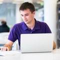 Handsome college student using his laptop