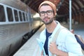 Handsome commuter smiling while waiting for his train Royalty Free Stock Photo