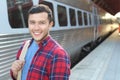 Handsome commuter smiling while waiting for his train Royalty Free Stock Photo