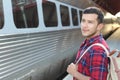 Handsome commuter smiling while waiting for his train Royalty Free Stock Photo