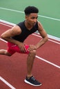 Handsome concentrated african athlete man make stretching exercises