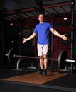 Handsome concentrated  brutal man dropping down the barbell in crossfit gym on dark sport club background with shadows Royalty Free Stock Photo