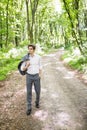 Handsome confident business man in suit walking in green park. Business concept. Royalty Free Stock Photo