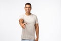 Handsome confident and friendly young masculine man in t-shirt, stretch hand forward for handshake, smiling say nice to