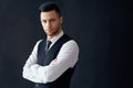 Handsome confident man in elegant suit with crossed arms on black background Royalty Free Stock Photo
